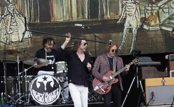 Dynamic rock band performing live with instruments, stage lights, and energetic stage presence.