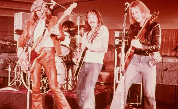 Musicians playing guitars and drums during a lively concert, highlighting rock music and band performance.