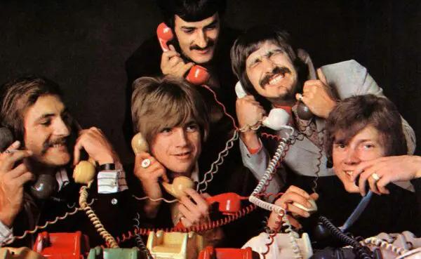 A group of men communicating with various colored phones, embodying fun and camaraderie.