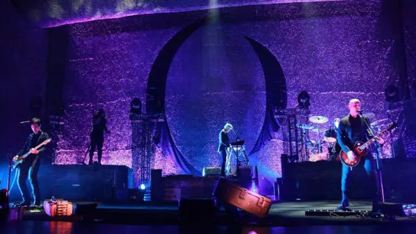Colorful stage with musicians performing under purple LED lights, creating an energetic live music scene.