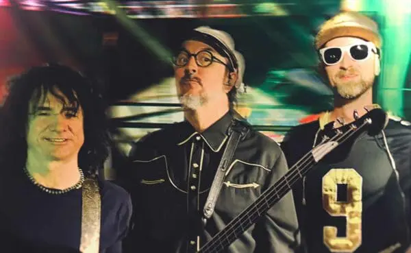 High-energy music scene featuring diverse band members with musical instruments, vibrant lighting.