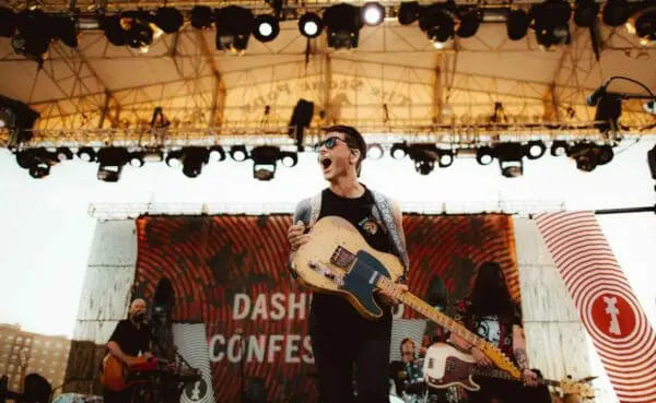 Vibrant outdoor concert scene with musicians performing passionately under stage lights.