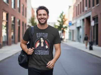 A man smiling outdoors in an urban setting, wearing a Morrissey T-shirt featuring an artistic portrait of Morrissey, perfect for music and band merchandise fans.