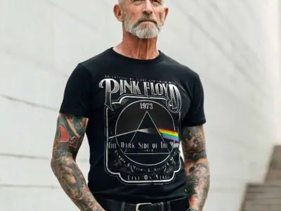 Bold tattooed man wearing a Pink Floyd concert t-shirt, showcasing vintage rock band style and music fan fashion.