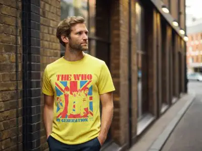 A man wearing a vibrant yellow The Who band t-shirt in an urban street setting, showcasing vintage music apparel and street style fashion.