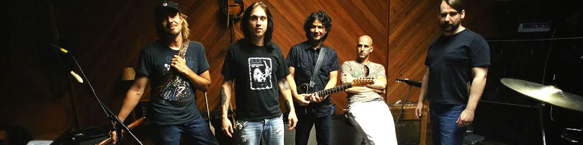 Musicians practicing in a recording studio with instruments and sound equipment.