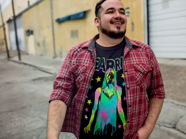 Colorful casual style featuring graphic T-shirt and plaid shirt in urban setting.