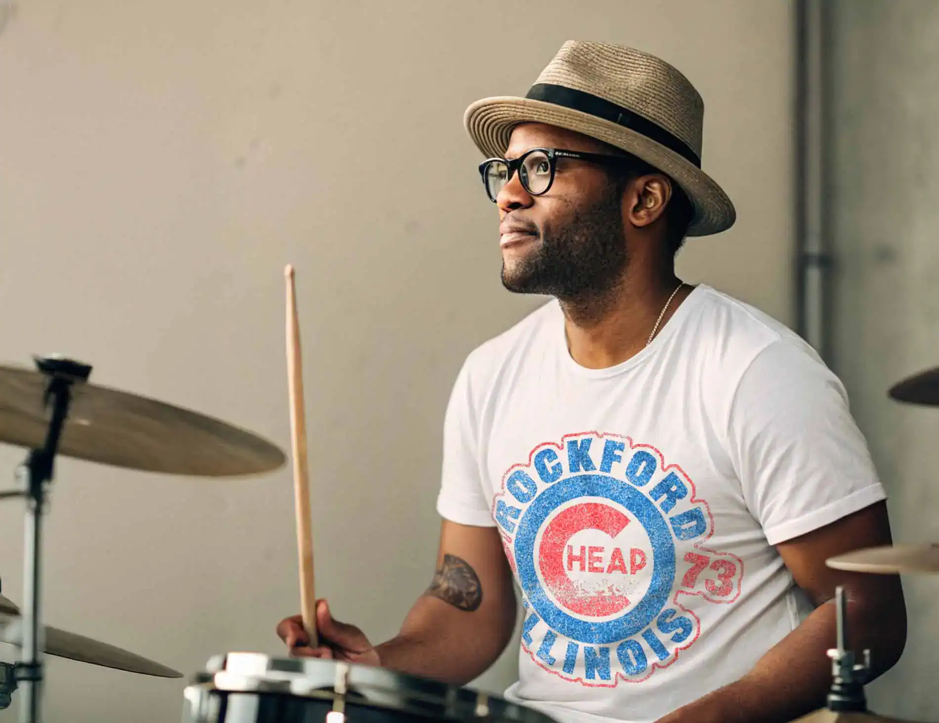 Man on a drum set wearing a Cheap Trick tee shirt