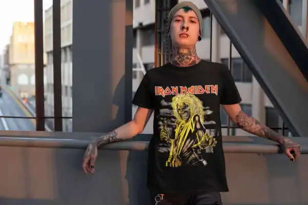 Bold punk rock style with an Iron Maiden graphic t-shirt, tattoos, and edgy accessories on an urban rooftop.