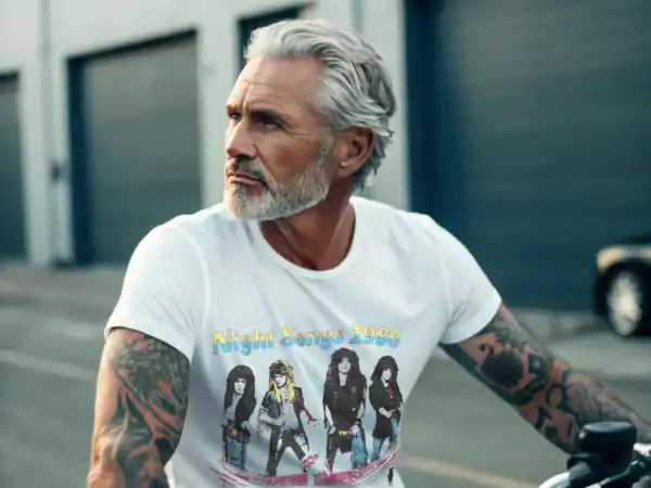 A vintage gentleman with tattoos wearing a Cinderella Night Songs 1986 T-Shirt