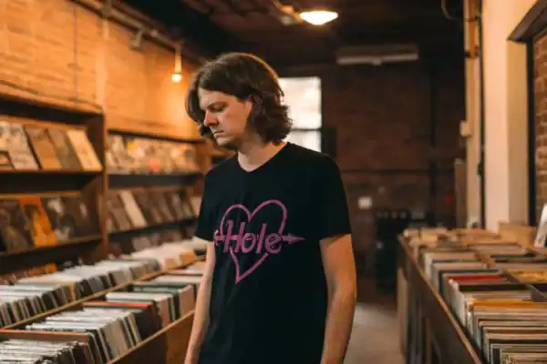 Young man with long hair wearing a black Hole t-shirt