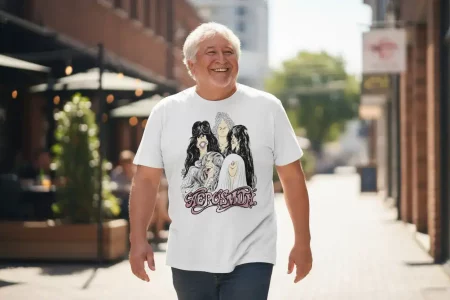 A happy man wearing a graphic rock band t-shirt walking downtown, showcasing urban fashion and music-inspired apparel.