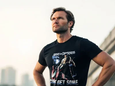 Caption: Stylish man showcasing a dark fantasy themed T-shirt with graphic art and bold message, perfect for fans of dark, fantasy fashion.