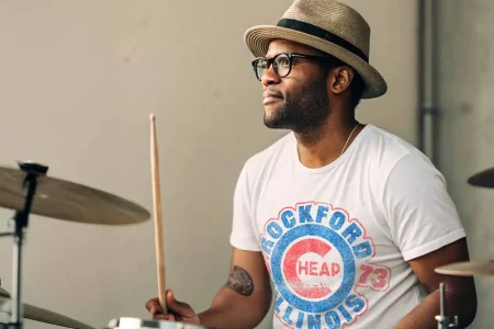 Man on a drum set wearing a Cheap Trick tee shirt