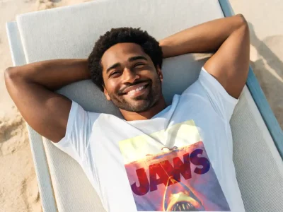 Happy man relaxing on a beach chair with a broad smile and sunlit background.