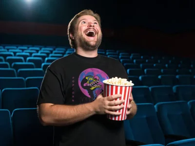 Happy man enjoying popcorn at a movie theater, entertainment, snack, leisure, fun experience.