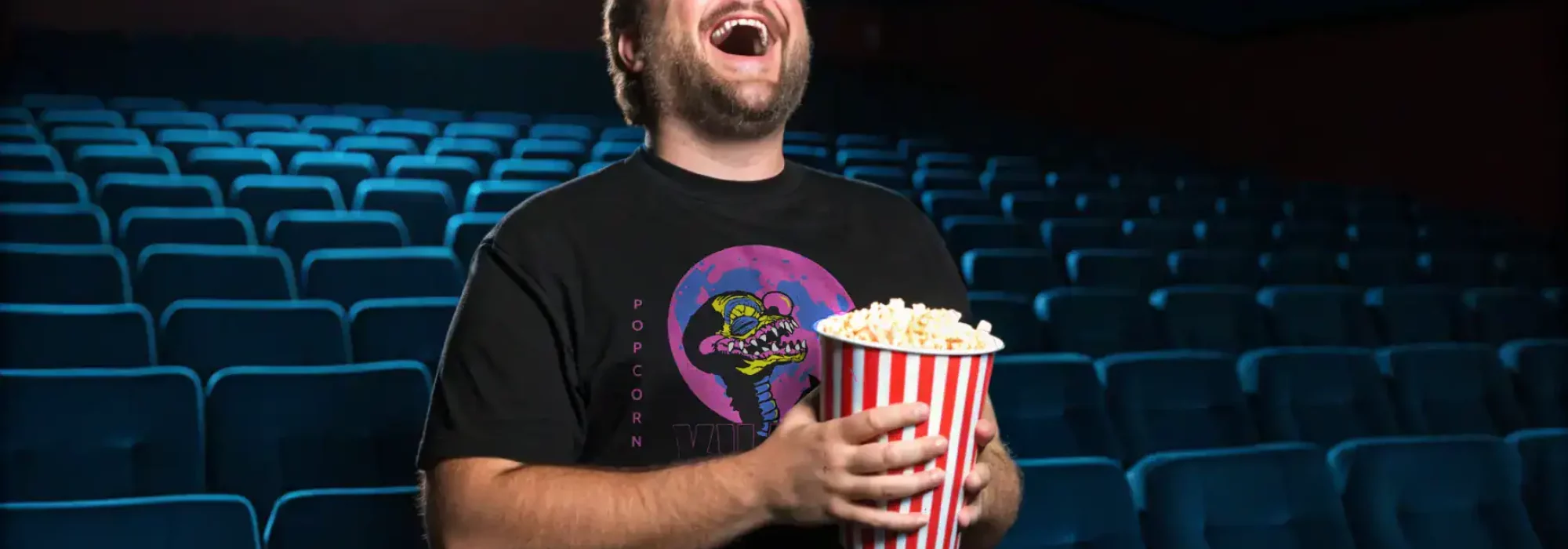 Happy man enjoying popcorn at a movie theater, entertainment, snack, leisure, fun experience.