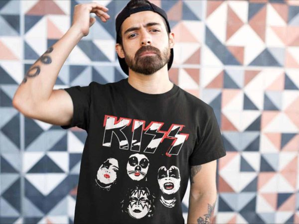 Striking young man with a beard in a black KISS band t-shirt standing in front of a vibrant geometric wall.