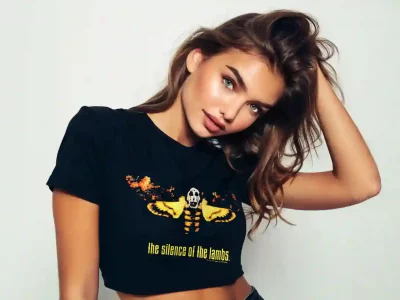 Young woman with wavy brown hair, striking eyes, and a confident expression, showcasing trendy casual fashion with a graphic tee.