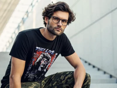 A stylish man wearing a graphic T-shirt with horror and streetwear design, casual pose, urban background.