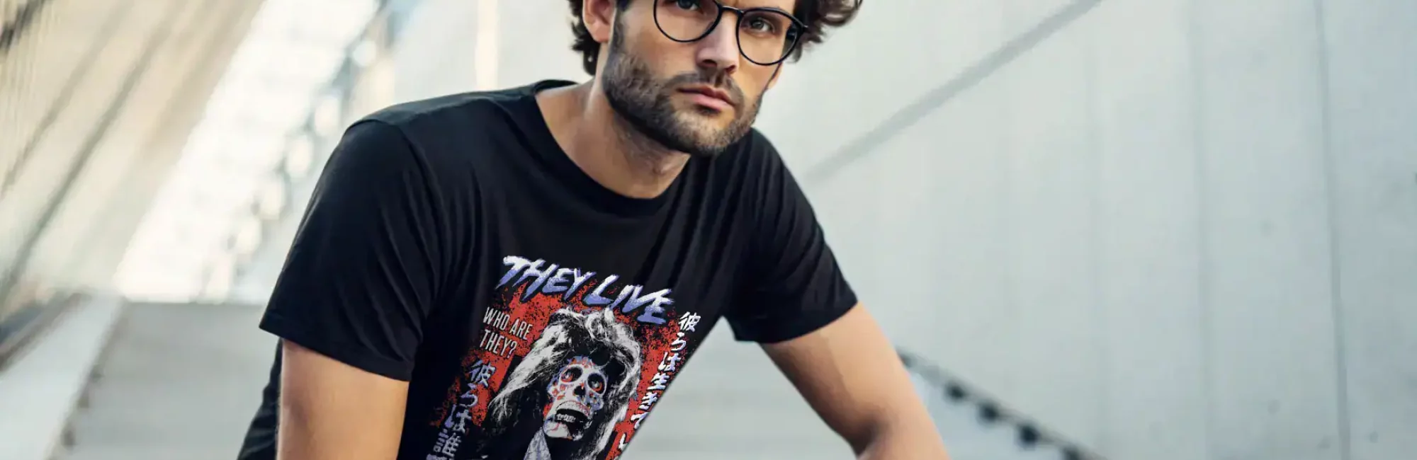 A stylish man wearing a graphic T-shirt with horror and streetwear design, casual pose, urban background.