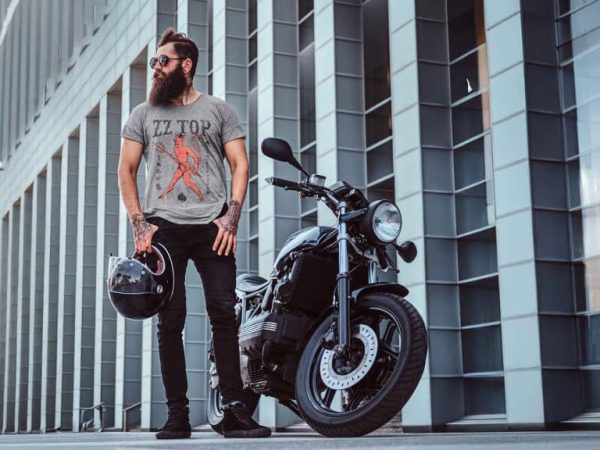 Rocker style man with motorcycle in urban cityscape, expressing cool, rebellious vibe. Perfect for motorcycle enthusiasts and urban fashion statements.