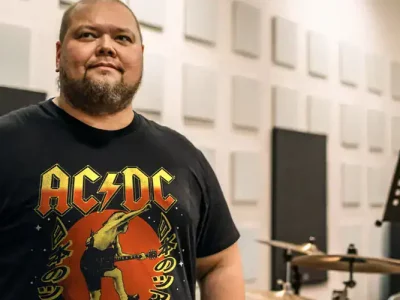 Music lover wearing AC/DC band t-shirt in professional recording studio environment.