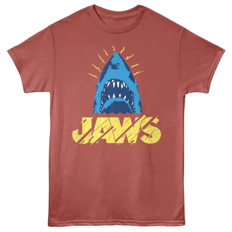 Bright blue shark head with sharp teeth, yellow "Jaws" text on distressed red background.