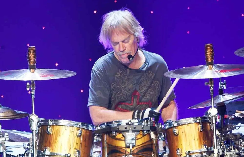 High-energy drummer performing on stage.