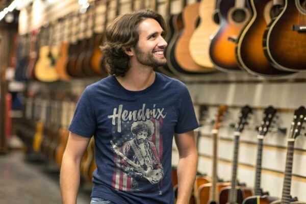 A smiling man browsing guitars in a musical instrument shop, featuring a variety of acoustic guitars hanging on display.