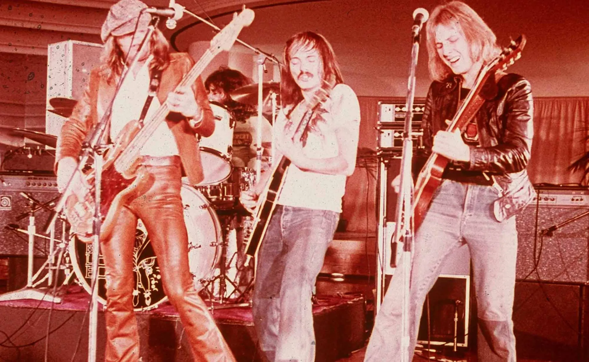 Musicians playing guitars and drums during a lively concert, highlighting rock music and band performance.