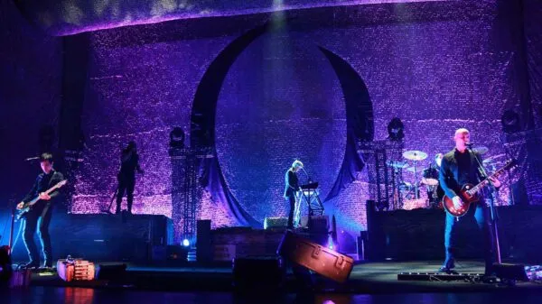 Colorful stage with musicians performing under purple LED lights, creating an energetic live music scene.