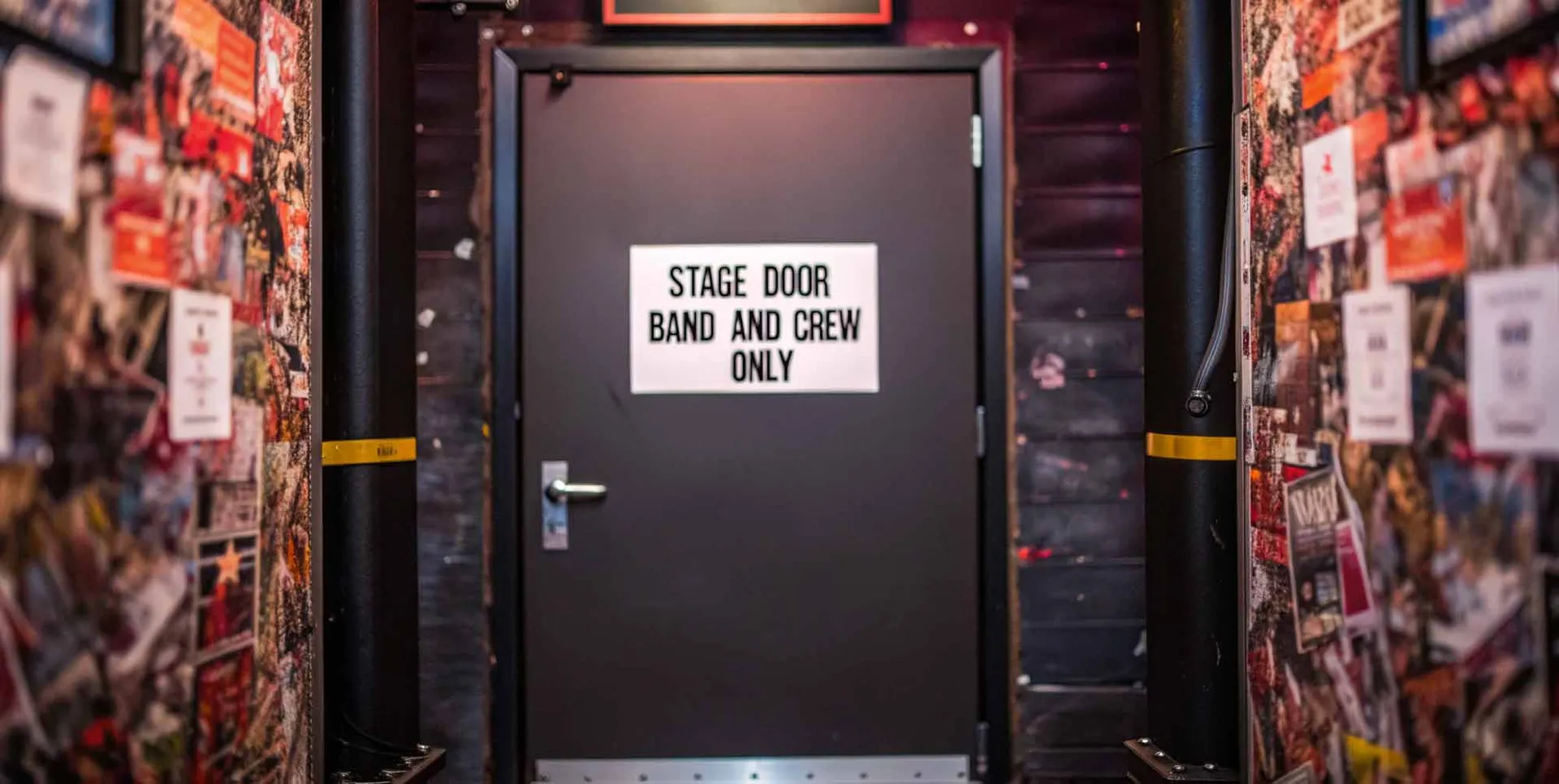 Door labeled "Stage Door Band and Crew Only" at a music venue or backstage area.