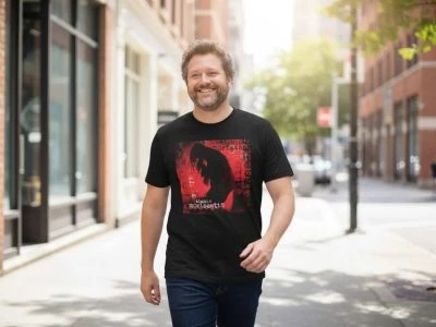 Expressive man wearing a graphic T-shirt with artistic design, walking confidently in urban environment, showcasing modern street fashion and confident personality.
