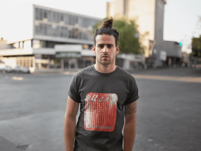Young man wearing a vintage Black Lunch T-shirt on city street during daytime, urban fashion, casual style, streetwear, modern men's clothing.